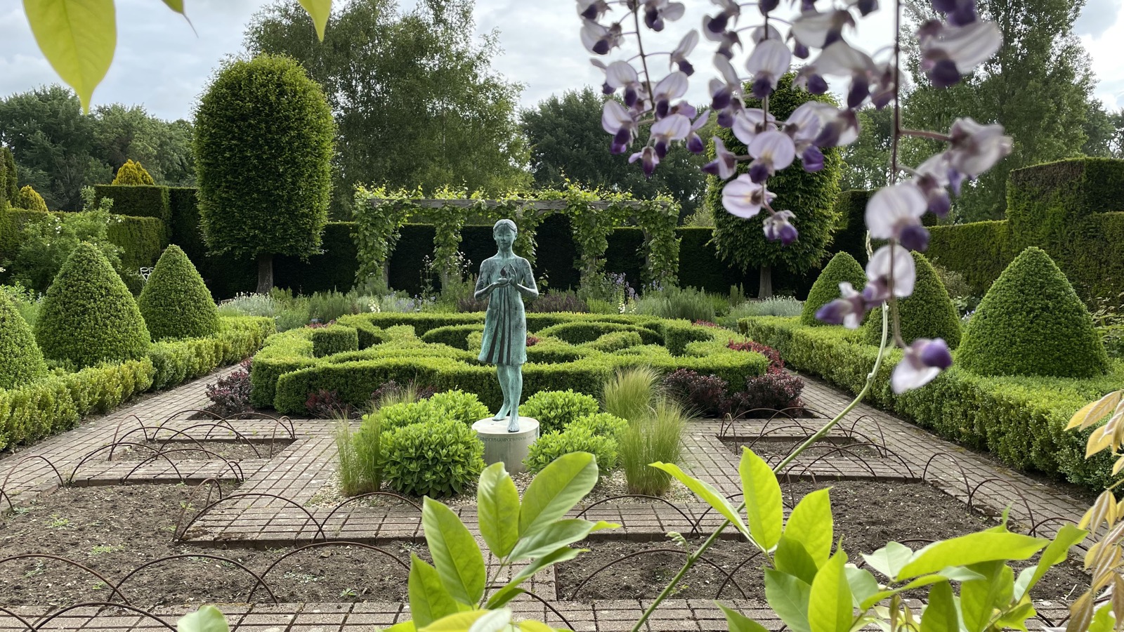 Bronze statue of a child in the formal knot garden at Waterperry House